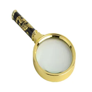 Detailopname van de handvergrootglas met een gouden frame en prachtig drakenhandvat.