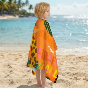 Leuchtend orangefarbenes Mikrofaser-Strandtuch mit Giraffenmotiv an einem sonnigen Tropenstrand