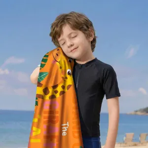 Kind hält ein weiches orangefarbenes Mikrofaser-Strandtuch mit Giraffenmuster am Strand