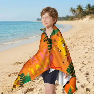 Detail eines Mikrofaser-Strandtuchs für Kinder mit Giraffen-Print an einem sonnigen Strand