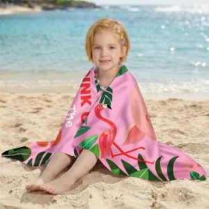 Detailansicht eines rosa Flamingo-Strandtuchs aus Mikrofaser, das ein Mädchen am Strand einhüllt