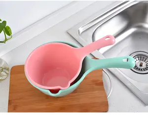 Vista detallada de cuchara de agua de plástico rosa y verde con mango largo para uso en cocina.