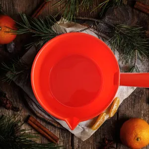 Poêle à beurre rouge détail vue rapprochée fond en bois rustique ustensile cuisine