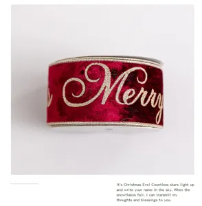 Dettaglio del nastro natalizio in velluto rosso vino con scritta 'Merry' glitterata oro.
