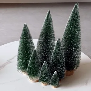 Close-up of frosted mini Christmas trees with wooden bases for holiday decor