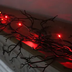 Close-up of spooky black Halloween vine garland with glowing red LED lights on a mantle.