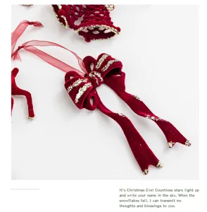 Macro view of a luxury burgundy flocked Christmas bow decoration with gold glitter trim
