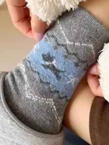 Close-up detail of winter thick warm retro Fair Isle knit socks with cute dog and bow pattern.