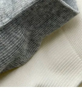 Close-up detail of soft breathable cotton knit sock fabric showing fine texture and quality.
