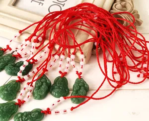 Colliers pendentifs Bouddha et Pixiu en imitation jade avec cordons rouges et perles.