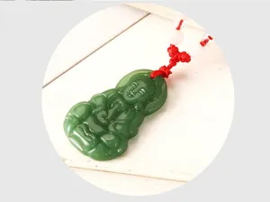 Pendentif Bouddha en imitation jade vert avec cordon rouge et perles roses, vue en gros plan.