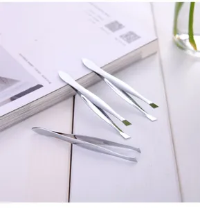 Stainless steel eyebrow tweezers detail, silver metal makeup tool close up view for precise hair removal.