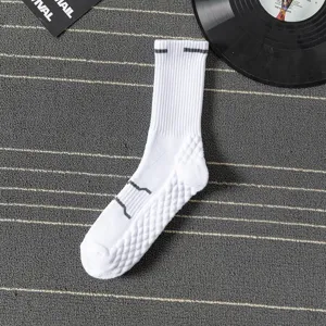 Men's white athletic mid-calf socks with striped details and thickened towel bottom close-up view.