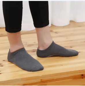 Men's non-slip yoga grip socks detail showing breathable dark grey fabric and textured dot soles.