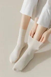 White crew socks detail view featuring soft cotton fabric and comfortable ribbed stretch cuff.