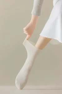 Detailed view of women's white mid-tube cotton socks featuring a flexible ribbed cuff design.