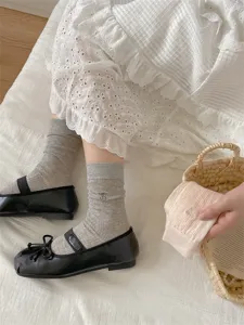 Detail shot of women mid-tube socks featuring cute bow embroidery and soft ribbed knit fabric.
