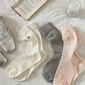Detailed view of summer ribbed bow socks in white, grey, and pink, delicate embroidered design.