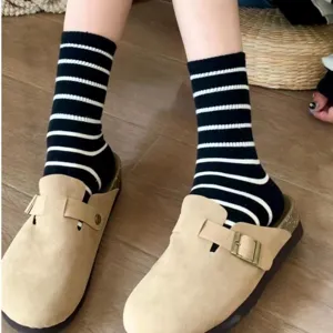 Black and white striped high socks with beige clogs, trendy casual footwear for women.