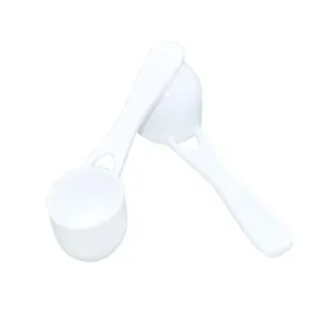 Detail view of white plastic measuring spoon, highlighting round bottom design for powder.