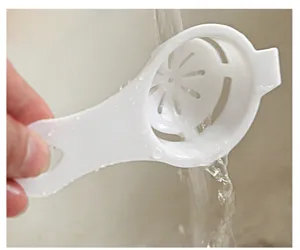 White plastic egg white separator kitchen tool with handle and filter holes for daily baking use.