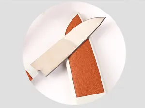 Detalle de cuchillo para fruta de acero inoxidable con funda naranja protectora y mango blanco.