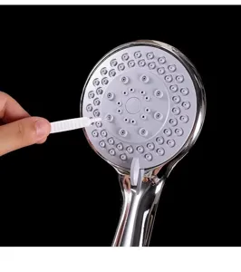 Detailed shot of a micro hole cleaning brush in action, showing precision tool for showerhead.
