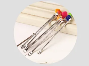 Vue detaillee de cure-oreille en acier inoxydable avec pendentifs coeur et anneau de cle.