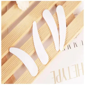 Detail shot of white plastic cosmetic spatulas for face mask and cream application.