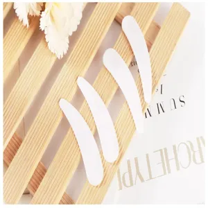 Detailed view of white plastic face mask spatula, curved design for DIY cosmetic cream dispensing.