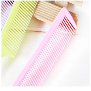 Close-up detail of colorful plastic hair combs featuring high and low teeth for daily styling.