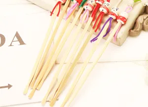 Natural handmade bamboo ear picks with cute wooden doll heads and colorful hanging ropes.