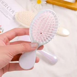 Portable macaron hair brush detail view, pink cushion comb teeth, daily cosmetic hair tool.