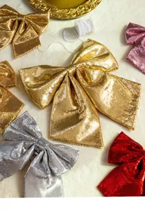 Detailed close-up of shiny sequin Christmas bows in gold, silver and red