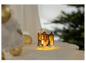 Warm glowing miniature resin Christmas fire station house ornament nestled in snow