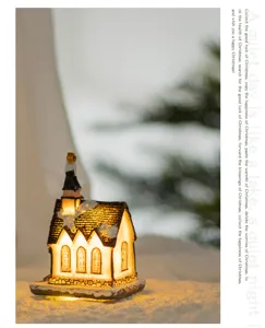 Detailed view of a glowing resin Christmas village house with warm LED interior lighting