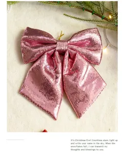 Close-up of a large pink sequined Christmas bow decoration with festive pine branch