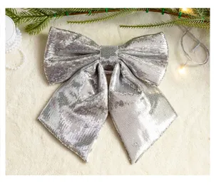 Detailed view of a large silver sequined Christmas bow on a cozy white rug