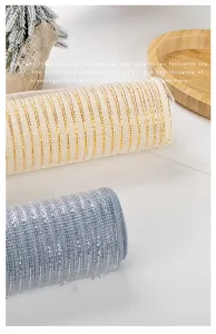 Close-up macro view of gold and silver Christmas decorative poly mesh ribbon rolls