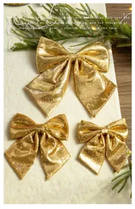 Detailed view of three golden sequined Christmas bows in varying sizes for holiday decor