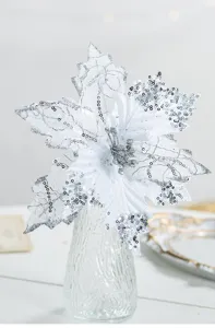 Close-up of white velvet Christmas flower with sparkling silver sequins in vase.