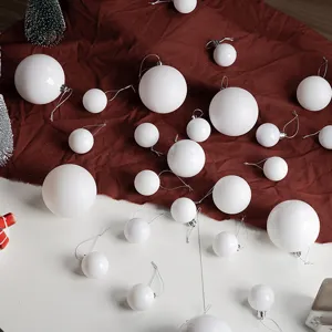 Collection of white Christmas ornaments in multiple sizes on festive red cloth background