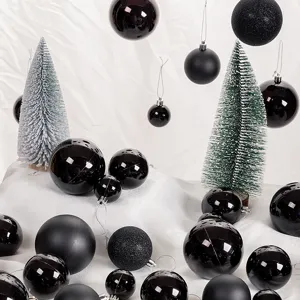 Close-up of decorative black Christmas balls in glossy, matte, and glitter finishes for trees
