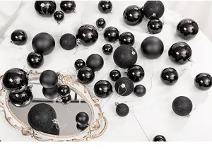 Variety of black Christmas ornaments with matte, glossy, and glitter finishes.