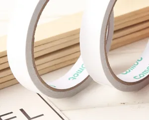 Close-up detail of household 18mm double-sided tape roll showing clean white adhesive surface texture.