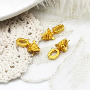 Makrodetail von 18K vergoldeten Weihnachtsbaum- und Muschel-Anhängern für DIY-Schmuck
