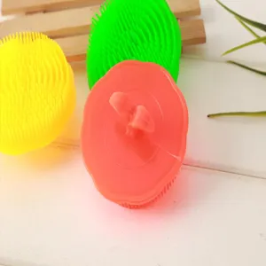 Silicone scalp massage brush detail view, soft rubber hair washing comb in multiple colors.