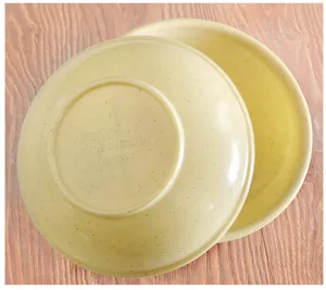 Close-up detail shot of a beige speckled melamine seasoning dish showing bottom embossed text.