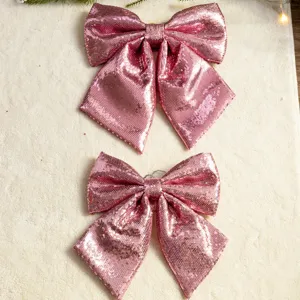 Pair of large pink sequin Christmas bows for festive holiday home hanging decoration.