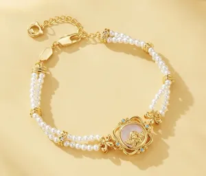 Vista detallada de pulsera de perlas de doble cordón con colgante de ángel oro